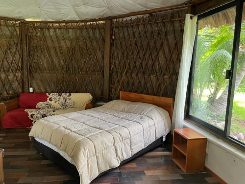 a bedroom with a bed in a yurt with a window at Xanthus Hotel in Huay Pix