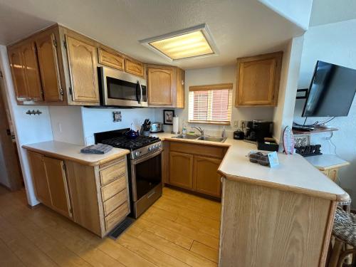 a kitchen with wooden cabinets and a stove top oven at Ocean Front Cabin 11 W Jacuzzi & Superb Views in Smith River