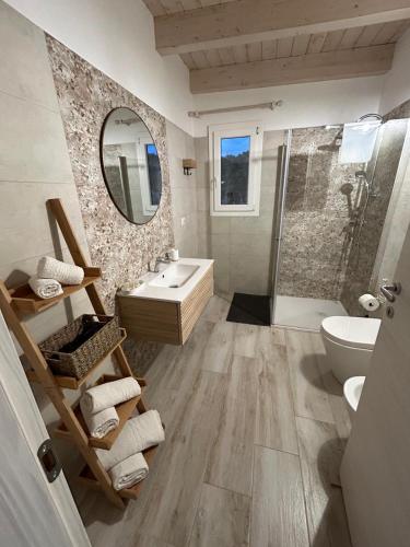 un bagno con doccia, lavandino e specchio di Camere Marisol a Porto Cesareo