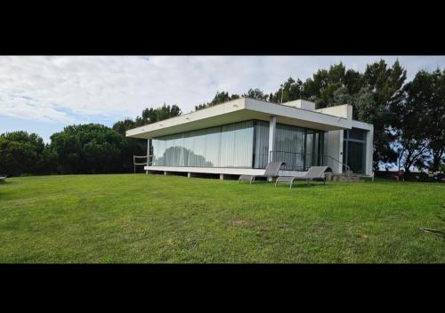 a large building with two benches in a field at Casa Oliveira in Casa da Ferraria