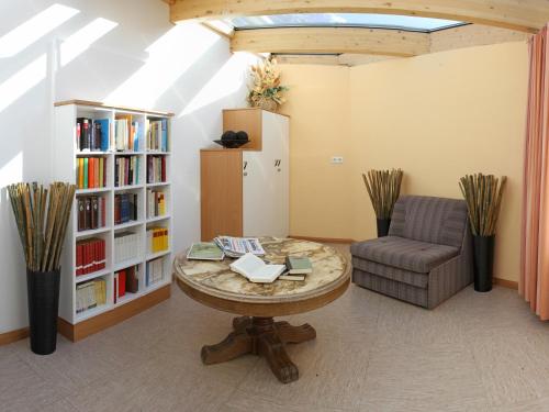 a room with a table and a chair and a book shelf at Residence Sonneck in Martello