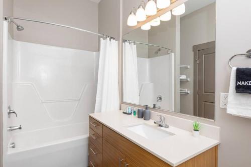 a bathroom with a sink and a shower and a mirror at Uptown Elegance Gym, Pool, Wine in Charlotte