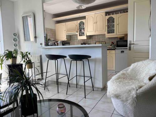 une cuisine avec un comptoir et des tabourets dans une pièce dans l'établissement Chambre avec vue panoramique sur la Cité Médiévale, à Carcassonne