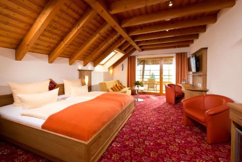 1 dormitorio con 1 cama y sala de estar en Silberkönig Schwarzwald Hotel & Restaurant Ringhotel, en Gutach im Breisgau
