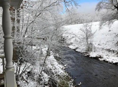 a winter view of a river with snow covered trees at Moonshine Creek Too in Bryson City
