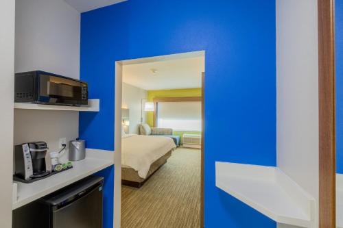 a hotel room with a blue wall at Holiday Inn Express & Suites - Lindale by IHG in Lindale