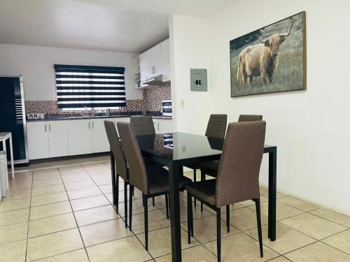 a dining room with a table and chairs in a kitchen at Departamento en zona dorada de Tijuana in Tijuana