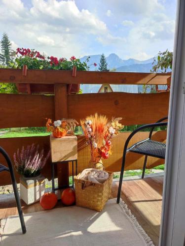 a balcony with a table and a basket of flowers at Mały Bystry Domek in Kościelisko