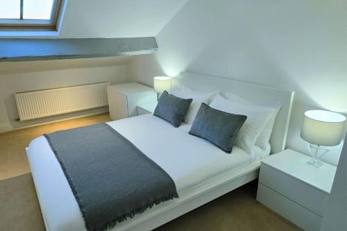 1 dormitorio con 1 cama blanca con 2 mesitas de noche y lámparas en Stylish City Centre Apartment with Parking, en Preston