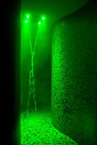 a green light in a dark room with a shower at Hotel Garnì Cristallo in Ponte di Legno