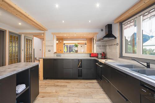 une grande cuisine avec évier et comptoir dans l'établissement Chalet les 4 saisons - Ski, parking et jardin, à La Chapelle-dʼAbondance