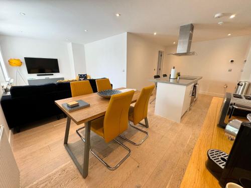 a kitchen and a living room with a table and chairs at Spacious & light 2bed, 2bath in the heart of Windsor in Windsor