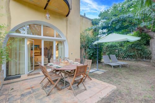 - une table, des chaises et un parasol sur la terrasse dans l'établissement Villa Azzurra Front Beach - Happy Rentals, à Saint-Tropez