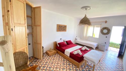 a bedroom with a bed with red pillows at Kali camp in Oualidia