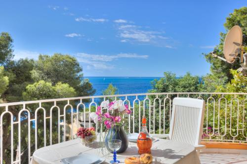 un tavolo con fiori in cima a un balcone di Studio Azur - Happy Rentals a Cap d'Ail