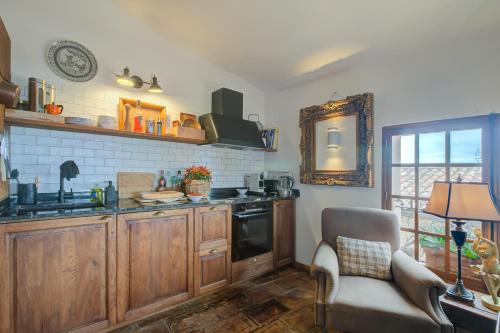 une cuisine avec des placards en bois, une chaise et une fenêtre dans l'établissement Maison Sans Delai - Happy Rentals, à Cagnes-sur-Mer