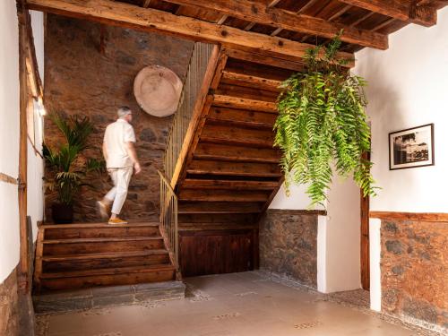 a man walking up a wooden staircase in a house at Laguna Cool Living in La Laguna
