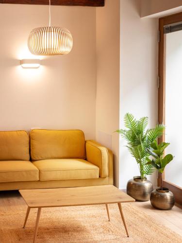 a living room with a yellow couch and a coffee table at Laguna Cool Living in La Laguna