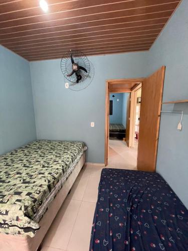 a bedroom with a bed and a fan on the wall at Casa com Piscina na Represa de Carlópolis in Carlópolis