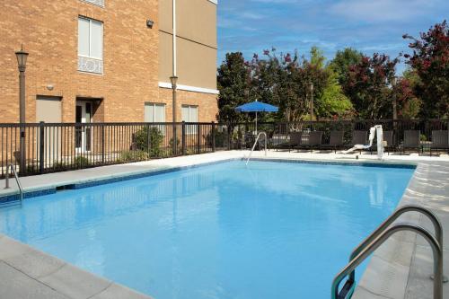 a large blue swimming pool in front of a building at Holiday Inn Express Hotel & Suites Greensboro - Airport Area by IHG in Greensboro