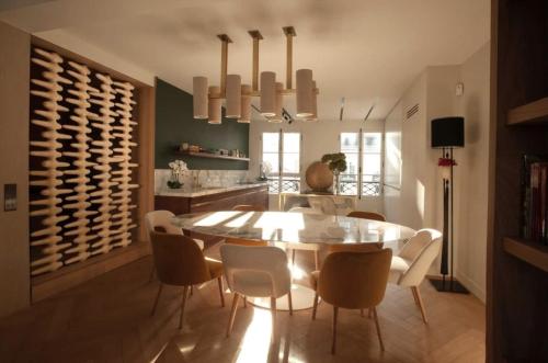 une salle à manger avec une table et des chaises ainsi qu'une cave à vin dans l'établissement Luxueux Appartement avec balcon, Champs Élysées, à Paris
