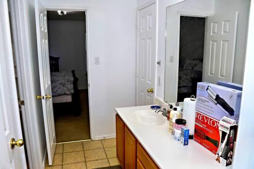 a bathroom with a counter with a sink and a mirror at Spacious 4-bedroom house with AC, Wi-Fi superb in the Heart of Arlington, TX! in Johnsons Station