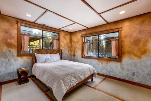a bedroom with a bed and two windows at New Cabin in North Lake Tahoe! in Kings Beach