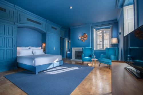 um quarto azul com uma cama e 2 cadeiras azuis em Villa Cascais Boutique Hotel em Cascais