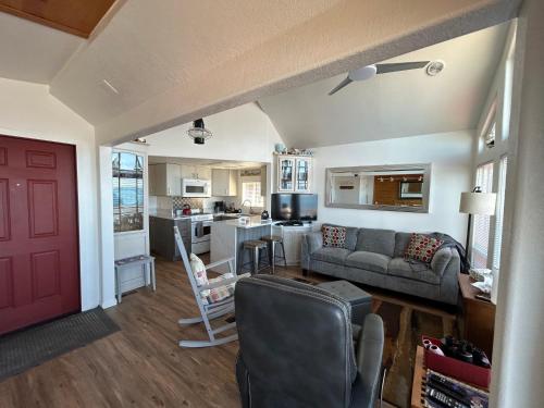 a living room with a couch and a kitchen at Oceanfront Cabin 10, Jacuzzi & Breathtaking Views in Smith River