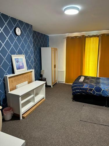 a bedroom with a bed and a clock on the wall at Gatwick Star Night Stay - Gatwick in Crawley