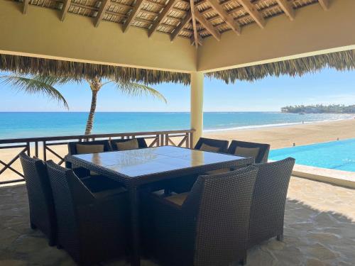 a table and chairs with a view of the beach at Luxury oceanfront condo, enjoy it ! in Cabarete