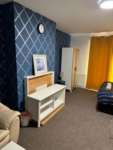 a room with a white cabinet and a blue wall at Gatwick Star Night Stay - Gatwick in Crawley