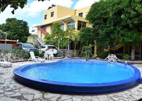 a large blue pool with chairs and a building at Hotel Mango in Boca Chica
