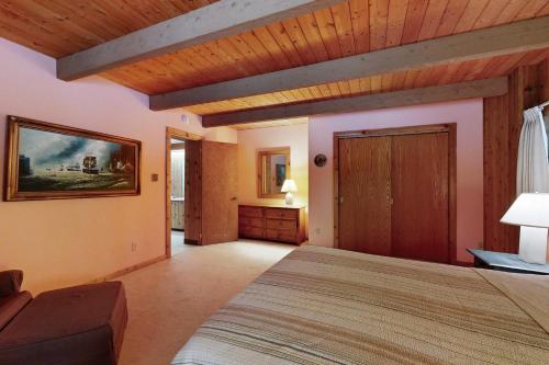 a bedroom with a large bed and a wooden ceiling at Secluded Mountain House in Forest Farms