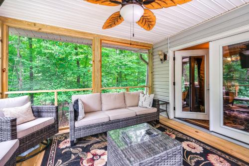 a screened in porch with a couch and a table at Home with Decks and River Access in Mt Gilead! in Albemarle