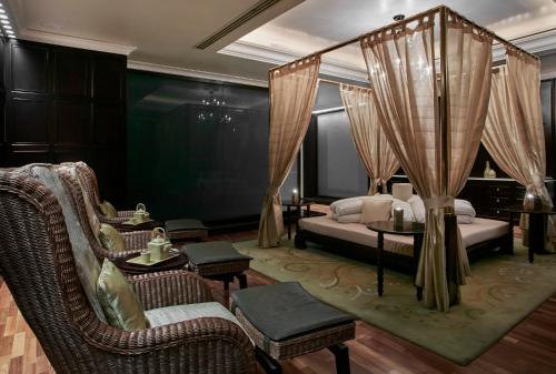 a bedroom with a bed and chairs and a couch at Holiday Inn Kuwait Al Thuraya City by IHG in Kuwait