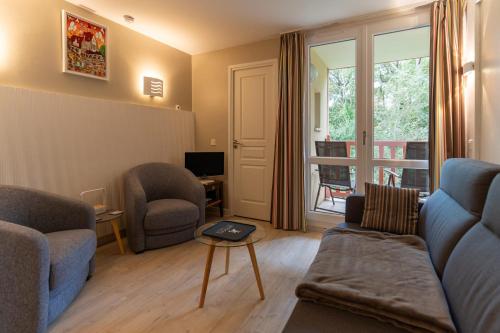 un salon avec un canapé, des chaises et une fenêtre dans l'établissement 6-person flat with swimming pool tennis court and free park 217, à Le Touquet-Paris-Plage