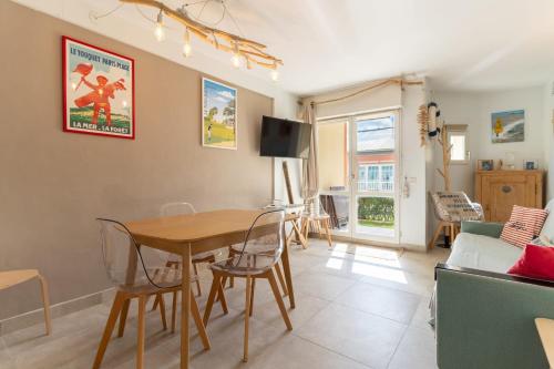 ein Wohnzimmer mit Tisch und Stühlen und einer Couch in der Unterkunft Appartement pour 4 pers avec piscine tennis et parking 56 in Le Touquet-Paris-Plage