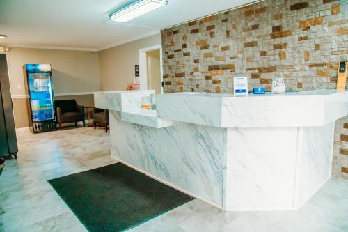 a lobby with a white counter and a brick wall at Country Garden & Suites in Benton