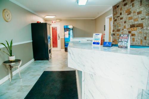 a lobby with a white counter and a brick wall at Country Garden & Suites in Benton
