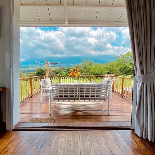 a porch with a table and chairs on a deck at Finca San Cayetano in San Juan Alotenango