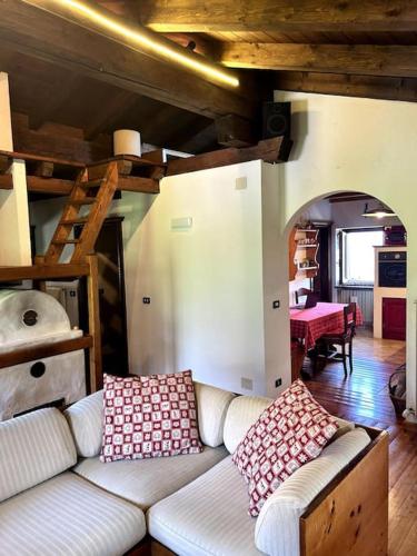 a living room with a white couch and a staircase at La Mansarda di Laura a Danta in Danta