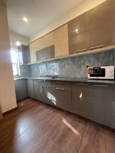 a kitchen with stainless steel appliances and wooden floors at Fellows BnB in Dhok Sandemār