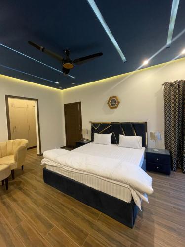 a bedroom with a large bed and a chair at Fellows BnB in Dhok Sandemār