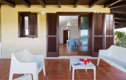 ein Wohnzimmer mit weißen Stühlen und einem Tisch in der Unterkunft Beach Front Home In Marina Di Modica in Marina di Modica