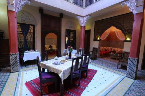 a dining room with a table and a couch at Riad Rêves D'orient & Spa in Marrakech