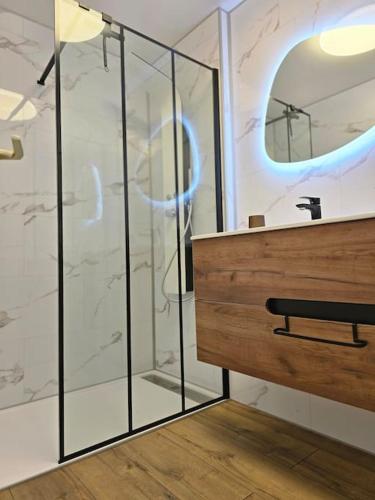 une salle de bain avec une douche, un lavabo et un miroir dans l'établissement Splendide appartement Standing Piscine, à Gérardmer