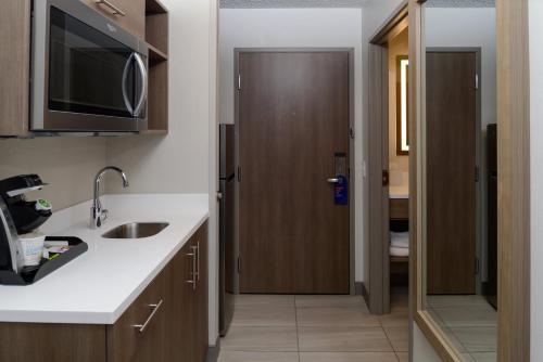 eine Küche mit einem Waschbecken und eine Tür zu einem Bad in der Unterkunft Holiday Inn Express Hotel and Suites Marysville by IHG in Marysville