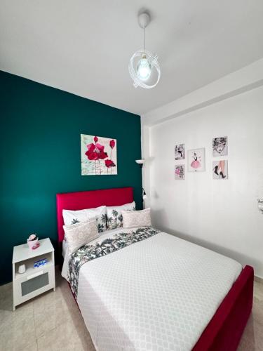 a bedroom with a red and white bed and a green wall at Charmant appartement á Tanger in Tangier
