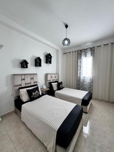 a hotel room with two beds and a window at Charmant appartement á Tanger in Tangier